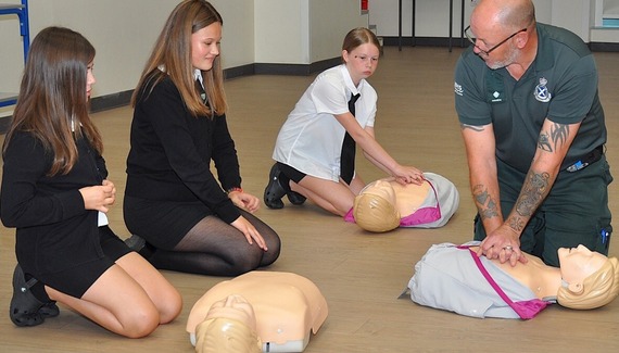 Students practice CPR on dummies