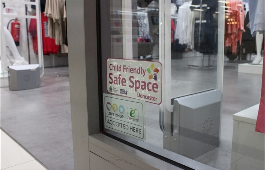 Photo showing a store window displaying a Safe Space sticker