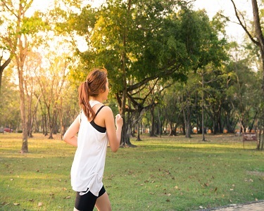 a woman in a park jogging 