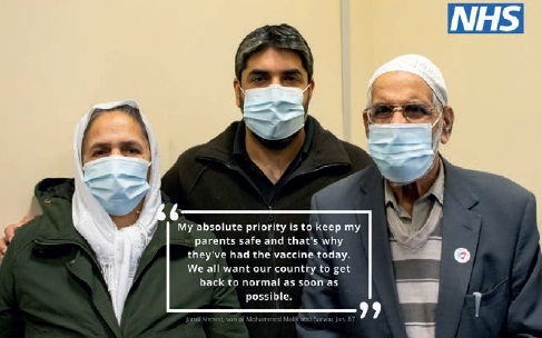 two men and a woman wearing a face mask getting their vaccine