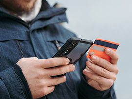 man holding mobile phone and credit card