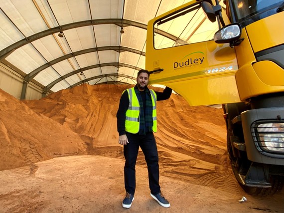 Councillor Shaz Saleem, with a mountain of sand in the background