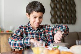 Child eating meal with knife and fork