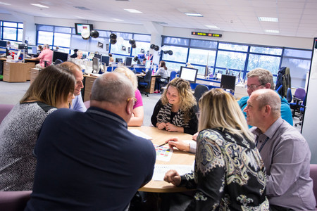 Contact centre staff sitting around a table