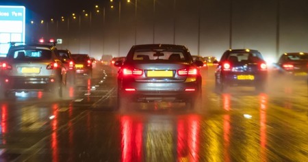 cars driving at night in the rain