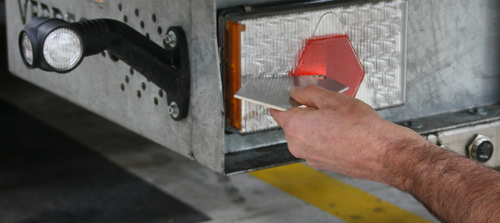 A DVSA tester doing a brakelight test