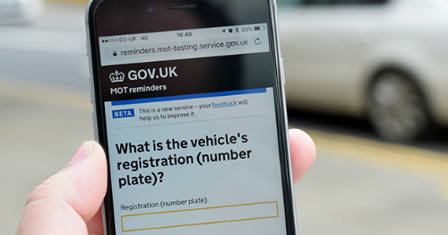 A phone with the MOT reminders service page