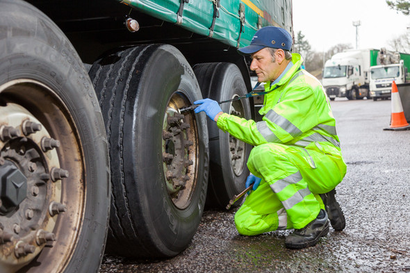 DVSA enforcement officer checking lorry tyre