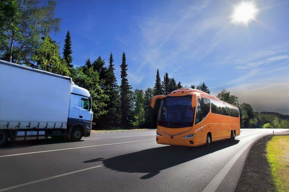 Orange bus with white lorry on road