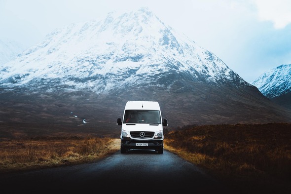 A white van in front of a mountain