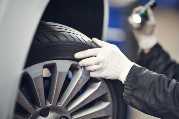 MOT tester inspecting a wheel