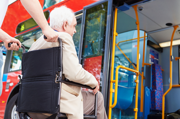 Wheelchair being pushed inside a red bus