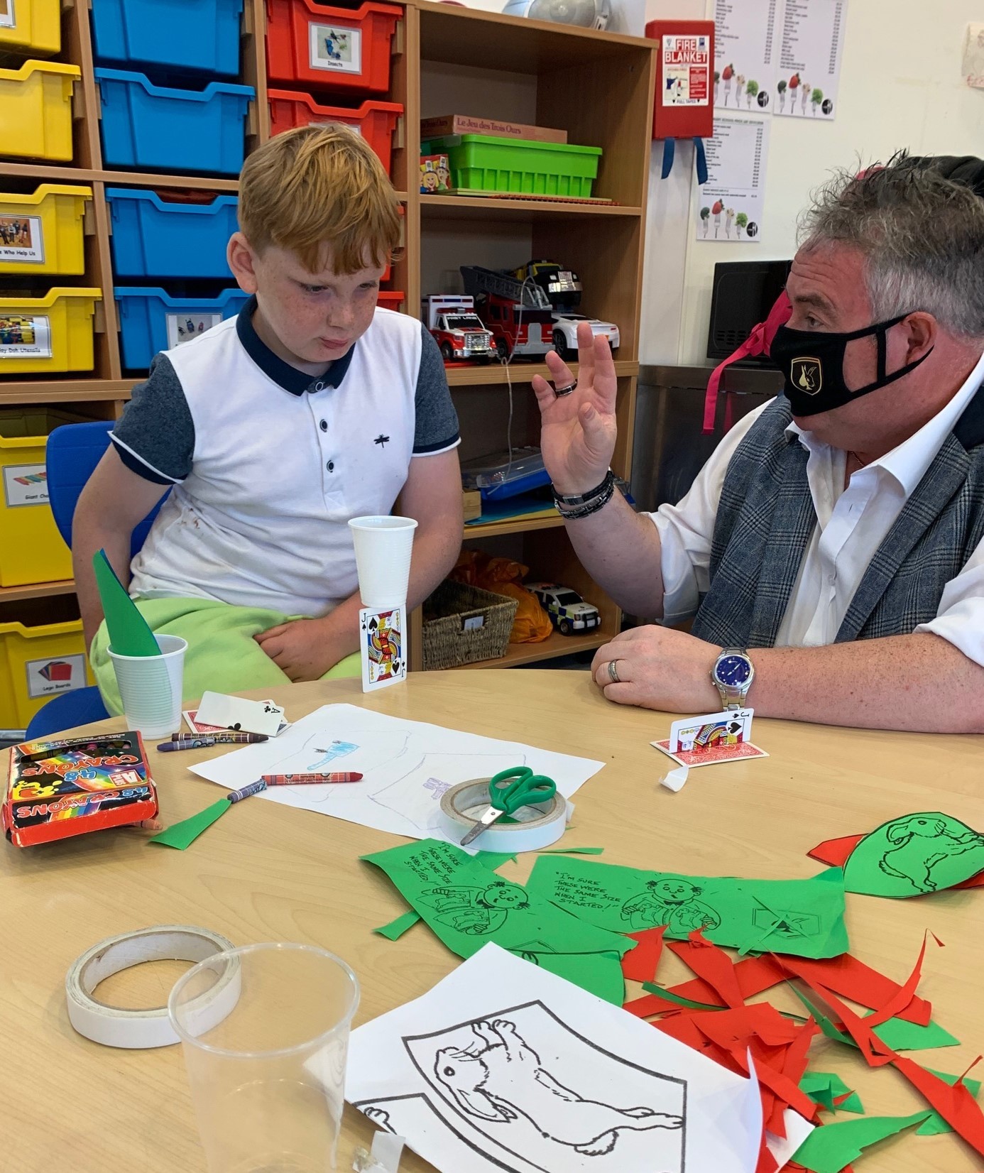Scotty teaching a little boy a magic trick