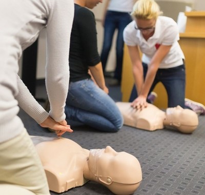 people taking part in a first aid class using dummy torsos
