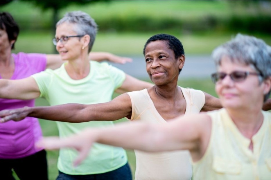 Three middle-aged women enjoying an outdoor exercise class together