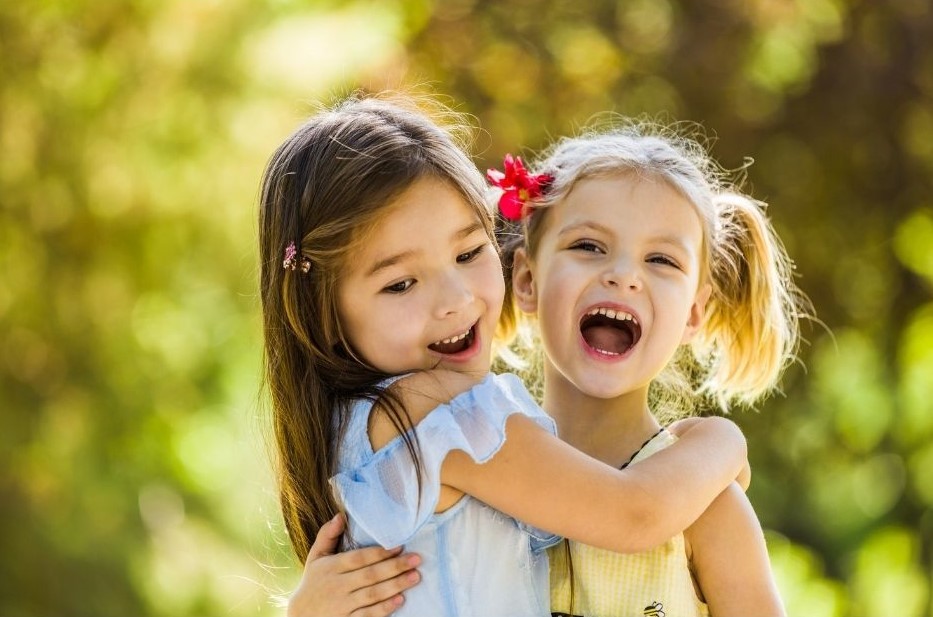 two little girls playing together outside