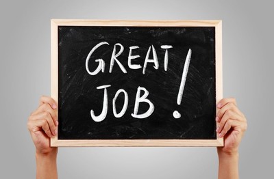man holding up a blackboard with the words 'great job!' written on it