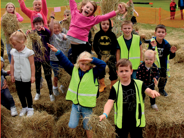 Children having fun among hay bales at an activity day