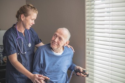 Female care worker helping man in wheelchair