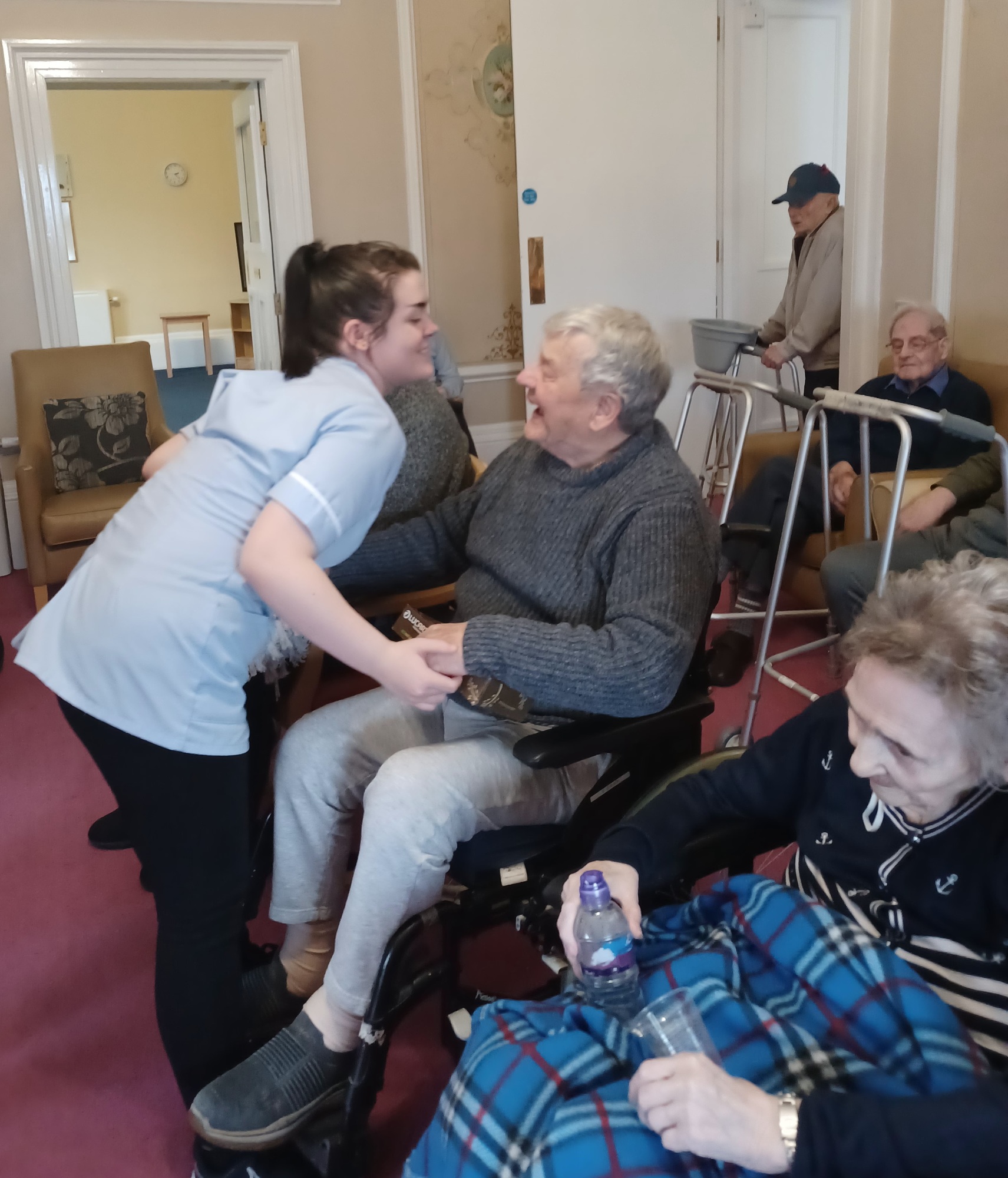 Care home worker and resident enjoying the music and dancing