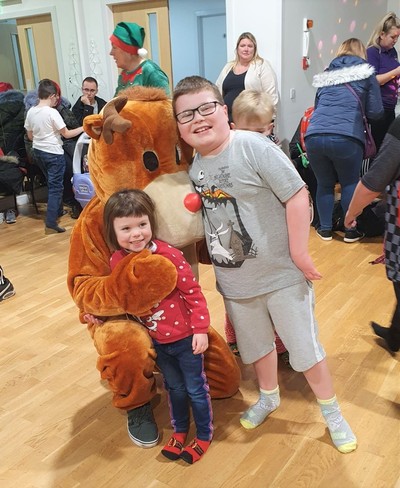 Children stand with Rudolph the reindeer at the ASN group's Christmas party