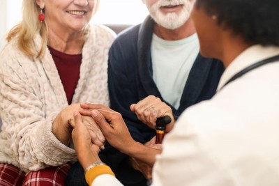 An elderly couple receiving help from an adult social care worker