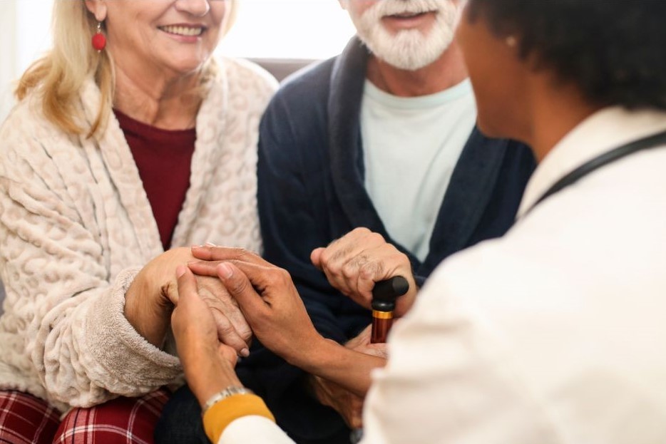 Elderly couple receiving help from an adult social care worker