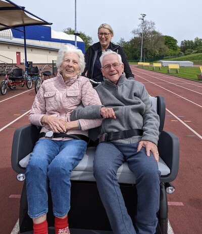 Two care home residents enjoying the All Ability Cycling event at Ayrshire Athletics Arena