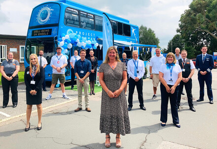 Staff from the Project Wingman Foundation standing outside one of their buses