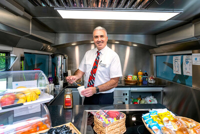 A Project Wingman team member serving refreshments on board one of the buses