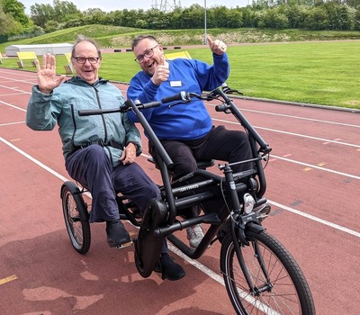 Two people cycling on an all ability bike at our Care Home Games last year