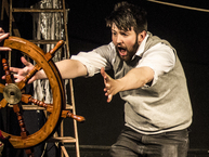 Man frantically reaching for the ship's wheel
