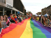 Crowds holding a long rainbow banner in Exeter High Street