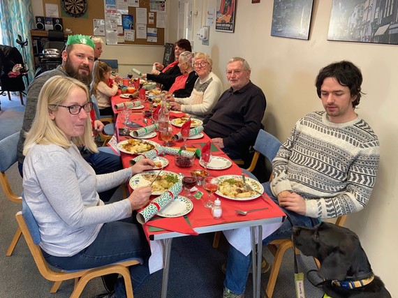 Warm hub users sit around a table for Christmas dinner