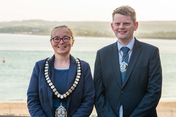 Photo of EDDC's Chair and Vice Chair taken on Wednesday, with Exmouth's coastline in the background(Credit EDDC and Kyle Baker Photography)