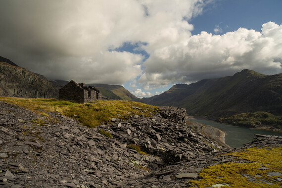 Photo 'End of mining' by Corinna Wagner - rocky landscape with a slate, roofless building and blue cloudy sky