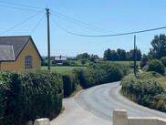 green field and yellow cottage 