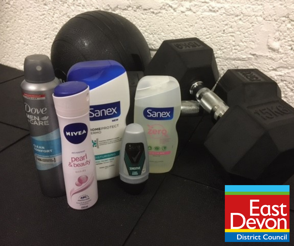 Photo of deodorant and shower gel bottles and gym weights