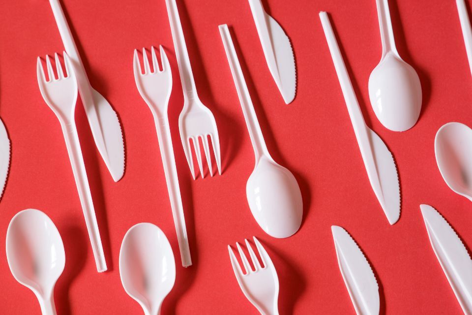 white plastic cutlery on red background