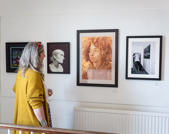 Photo of person looking at framed artwork on the wall at THG Open