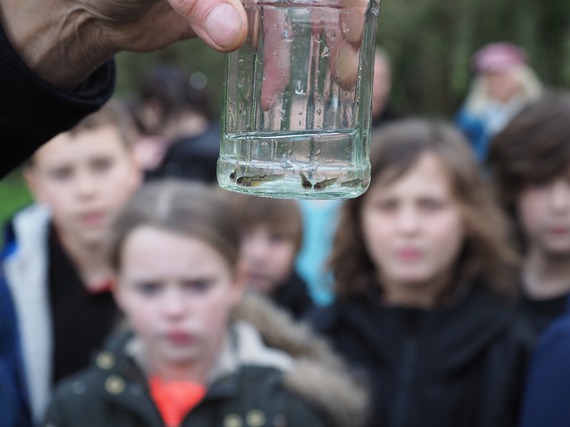 Photo of school children with a container of water with fish eggs in