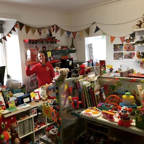 A no toys left behind volunteer surrounded by toys in their Axminster shop.  