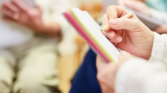 Photo of a person writing with a blurred background