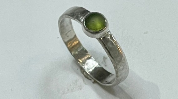 Photo of a silver ring with a green stone