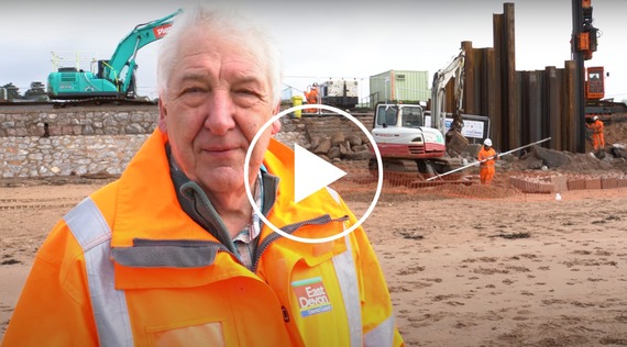 Screenshot from a video of Councillor Geoff Jung on Exmouth beach next to the sea wall repair work