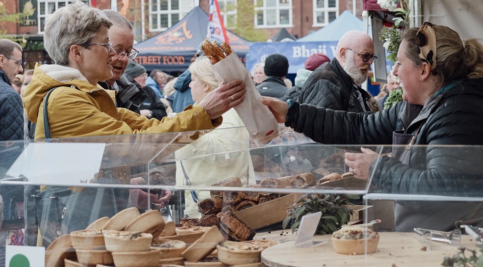 Photo of a stallholder passing a visitor some food at Exmouth Gate to Plate. Credit: Samantha Maddox
