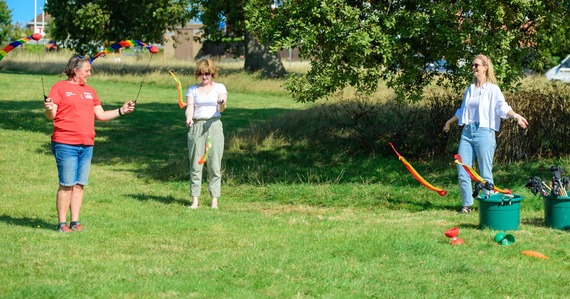 Photo of three people twirling ribbons in a park