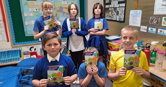 Photo of year 6 students at Littleham Primary school holding LED healthy families leaflets