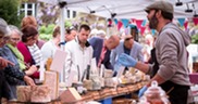Photo of a busy market stall selling cheese
