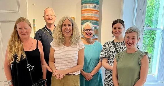 Six of the artists from the Seam Collective stand in the Thelma Hulbert Gallery